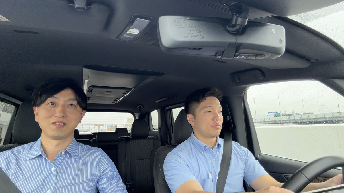 助手席の指導員が、運転する社員に声をかけながら同乗している様子